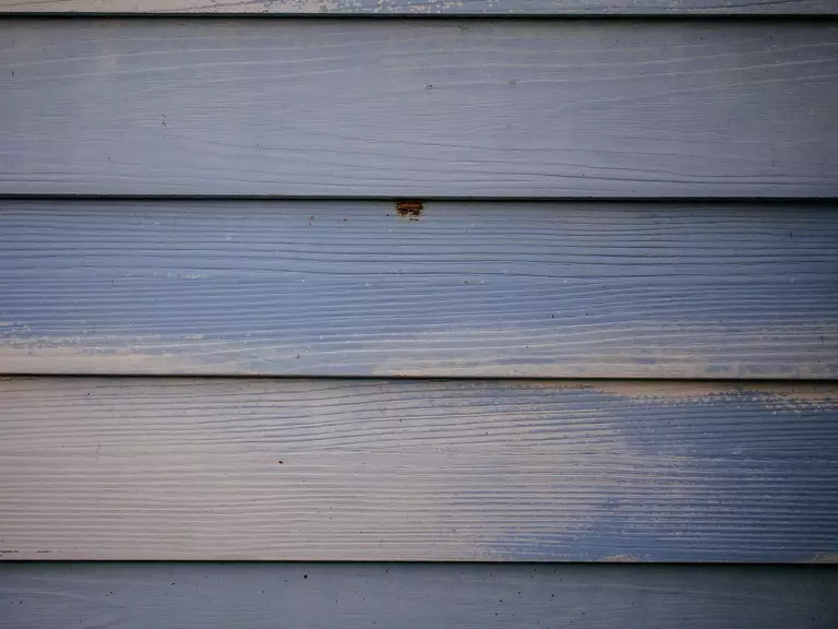 Close-up of vinyl siding with fading color.