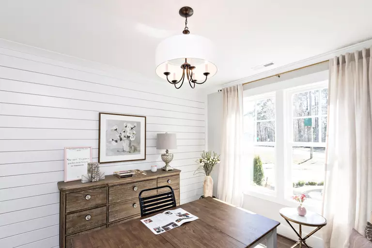 A newly renovated home office with wall accents, upgraded furniture, and replacement windows.