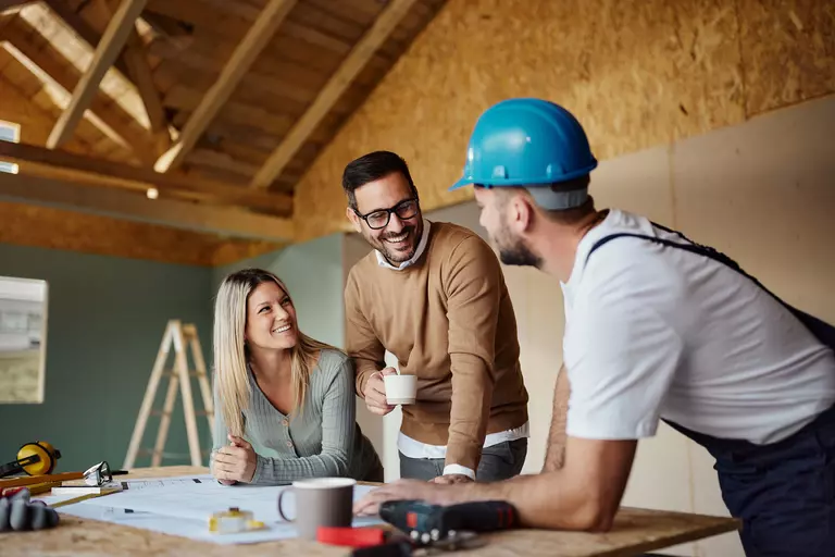 A husband and wife working with a contractor to plan their home renovation projects.