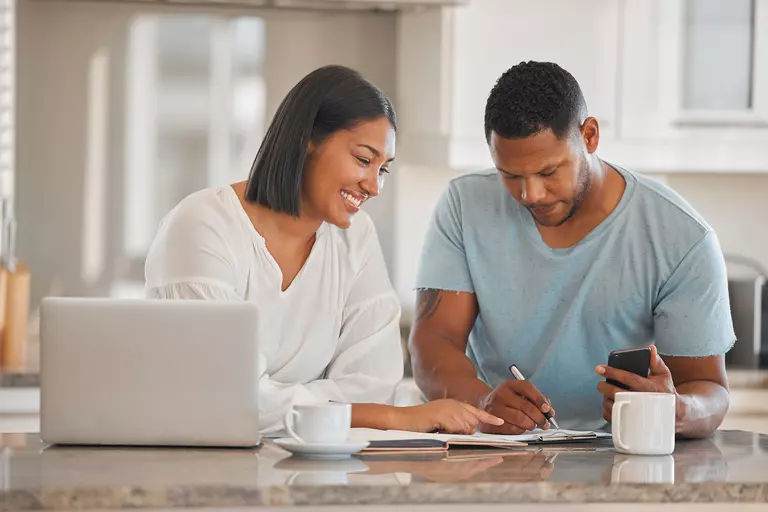 Woman and man working on a budget together at a kitchen island.