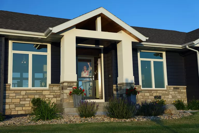 Woman on the inside of a home with a retractable storm door and windows installed.
