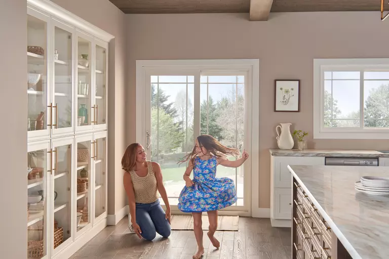 Woman and child inside a modern kitchen.