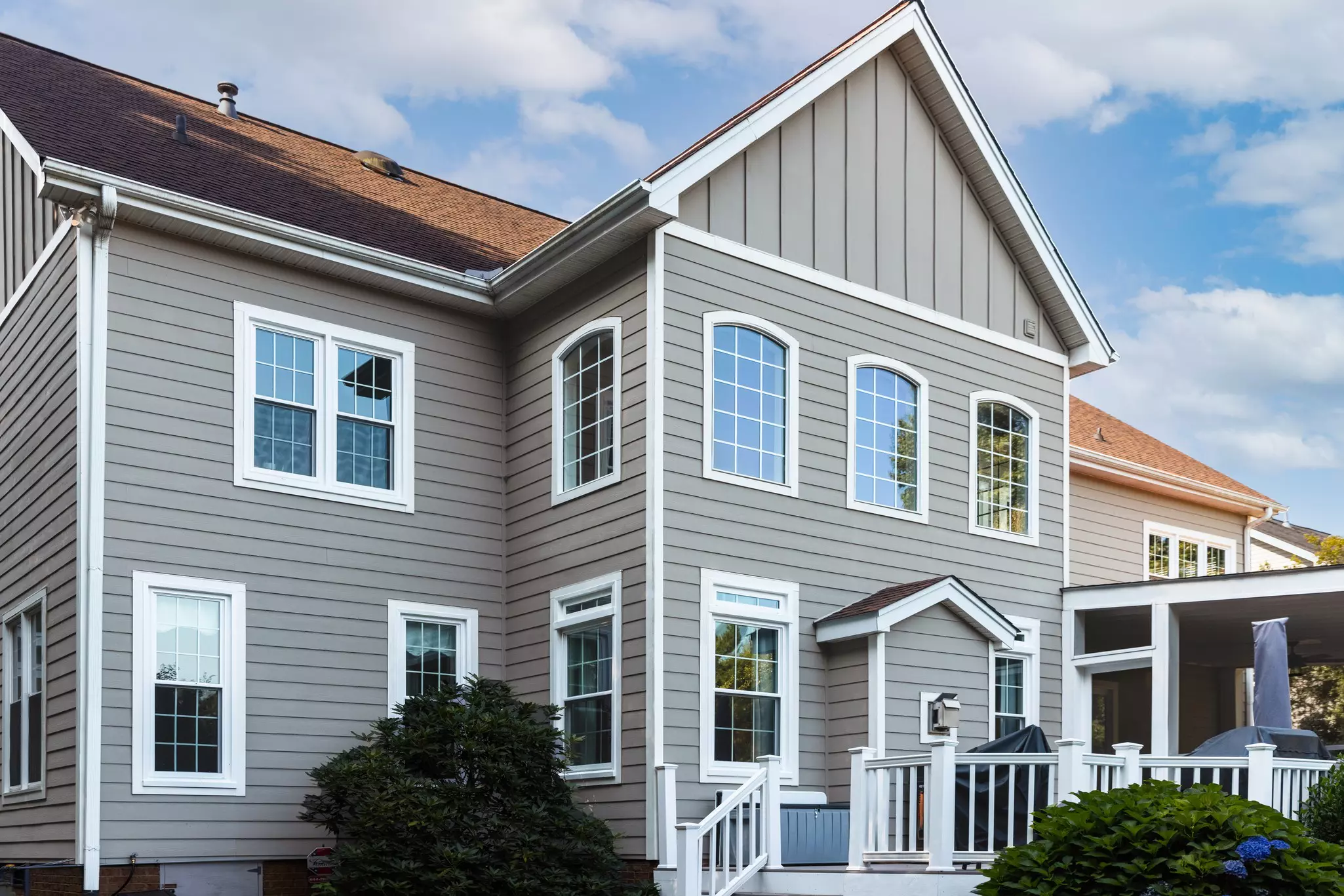 Gray two-story home with white replacement windows and porch.