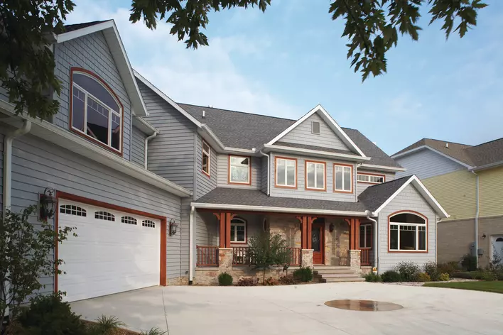 A large house with red and blue insulated vinyl siding