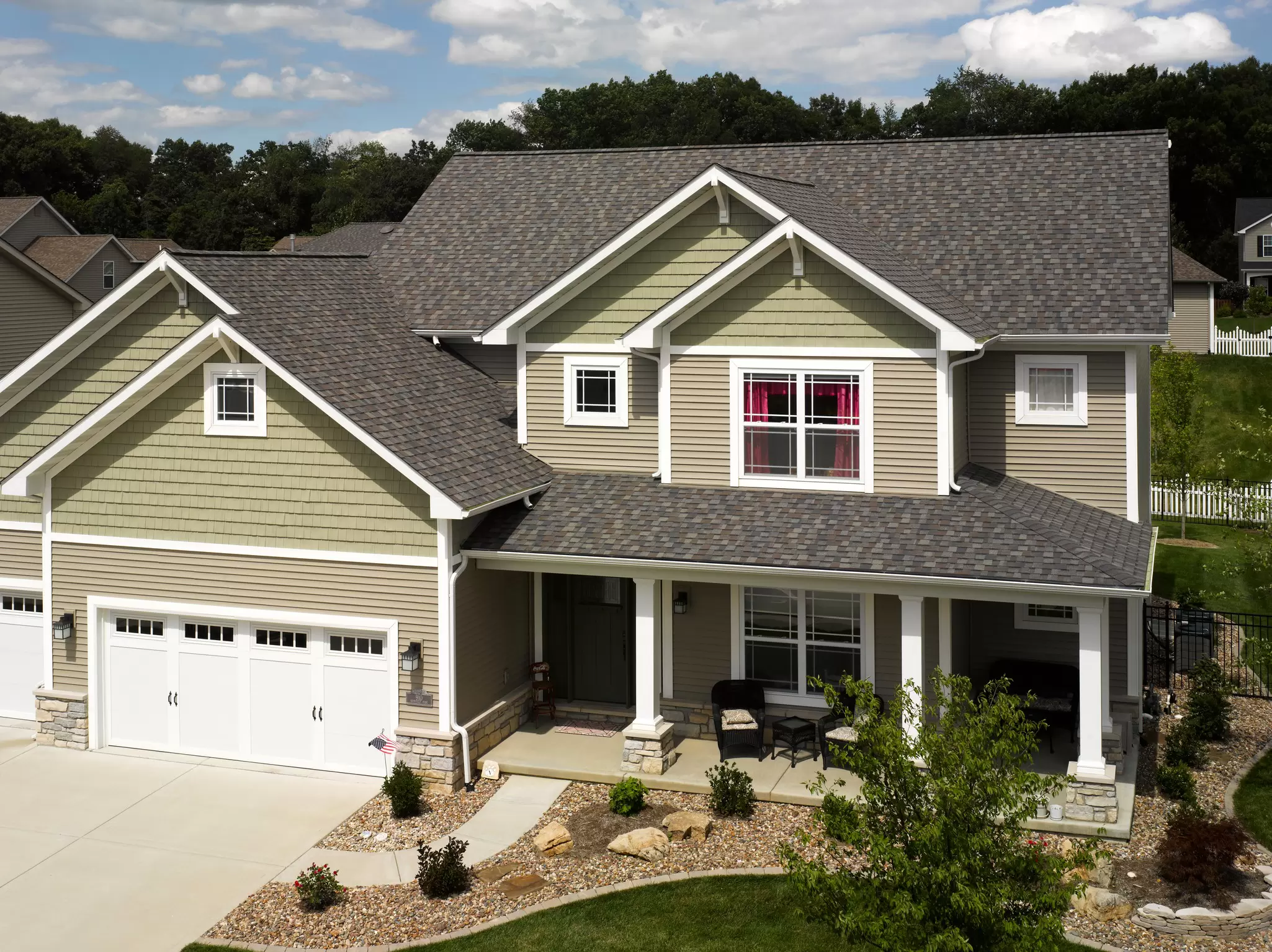 Lap siding on a two-story home with large, white-trimmed windows.