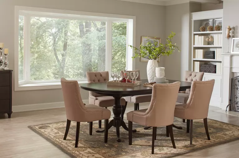 A dining room with a large bay window.