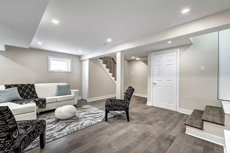 A finished basement serving as a living area that has an awning basement window installed.