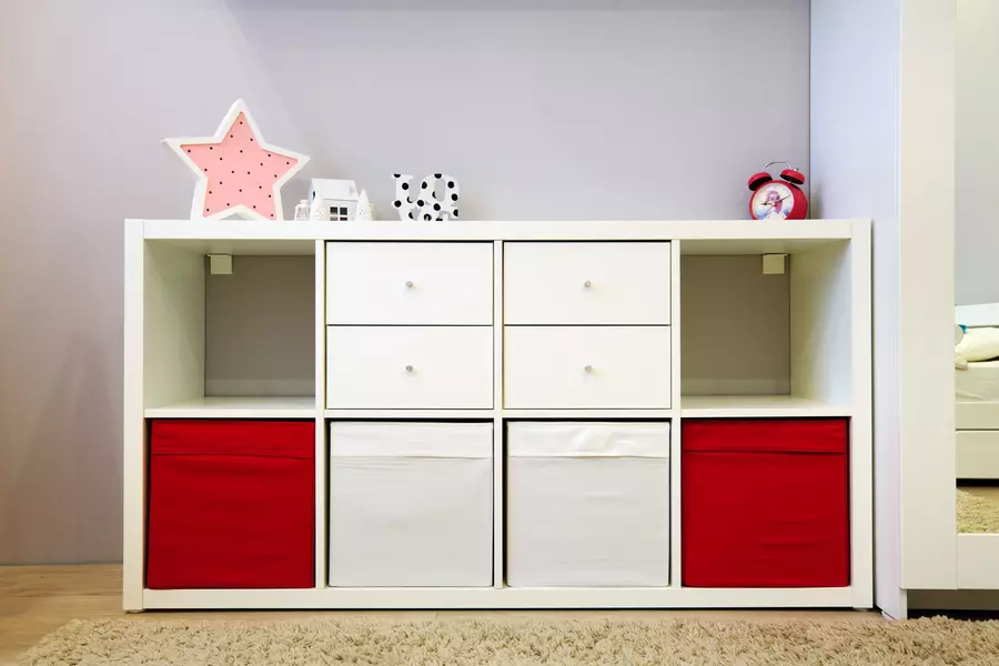 white organization bookcase with white and red bins as drawers