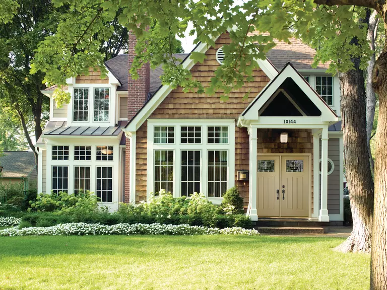 Home exterior with large mulled windows with grids.