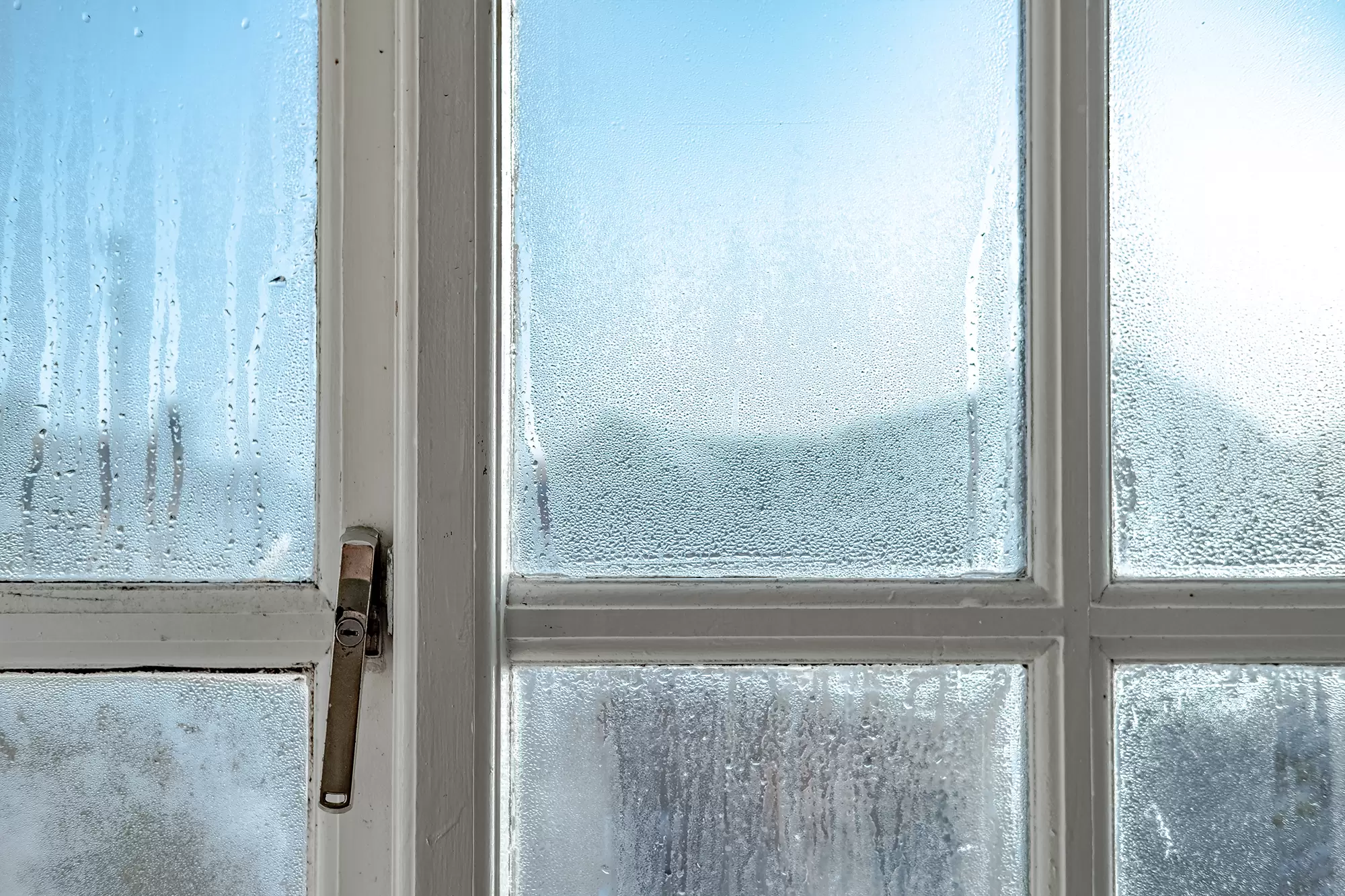 Condensation forming on an older window during winter.