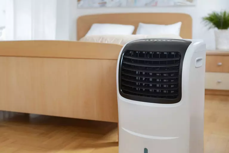 Evaporative swamp cooler in a minimally decorated bedroom.