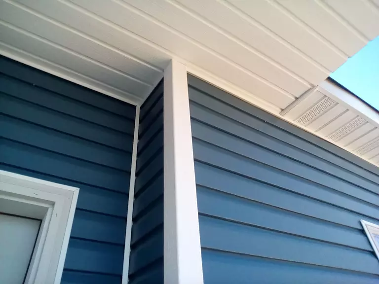 Close-up of a home with navy blue vinyl siding.