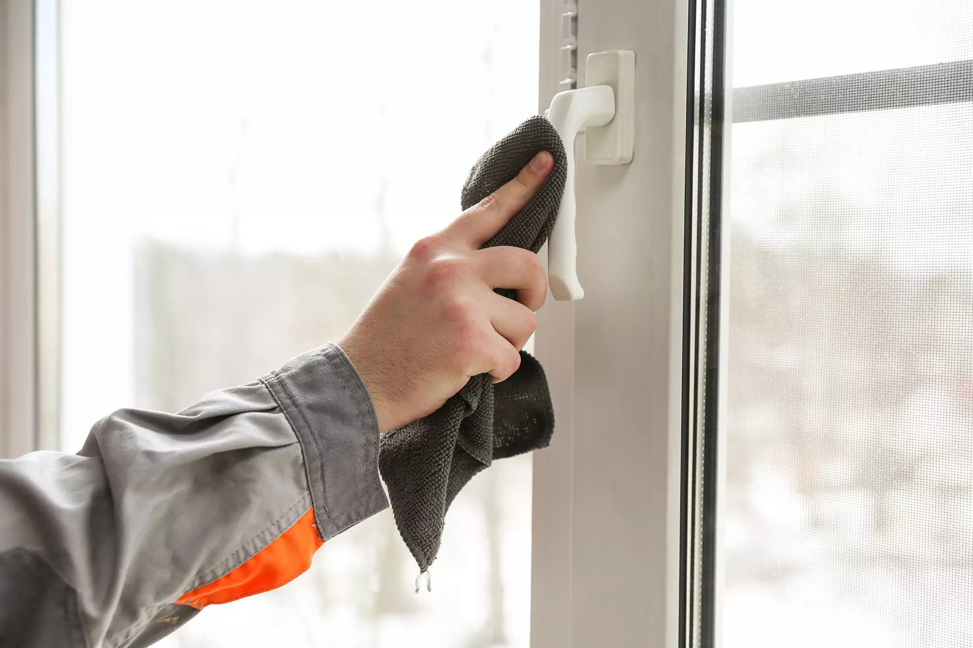 Person wiping handle of patio door.