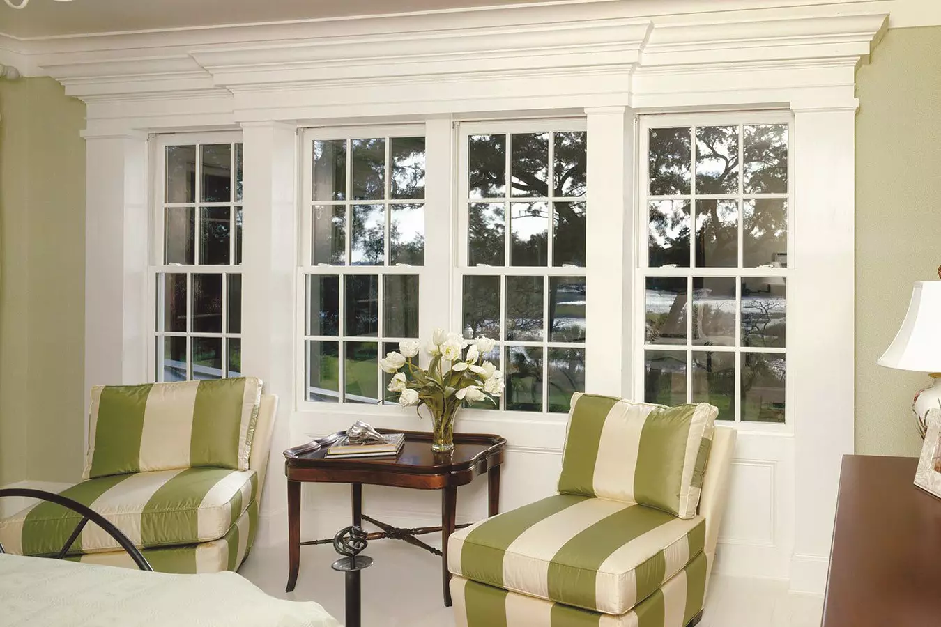 Living space with multiple white double-hung windows with grids.