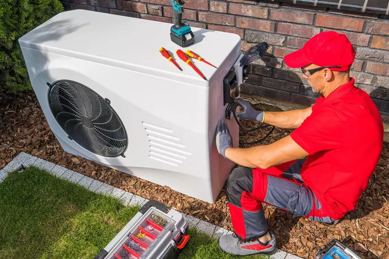 Contractor installing a heat pump.