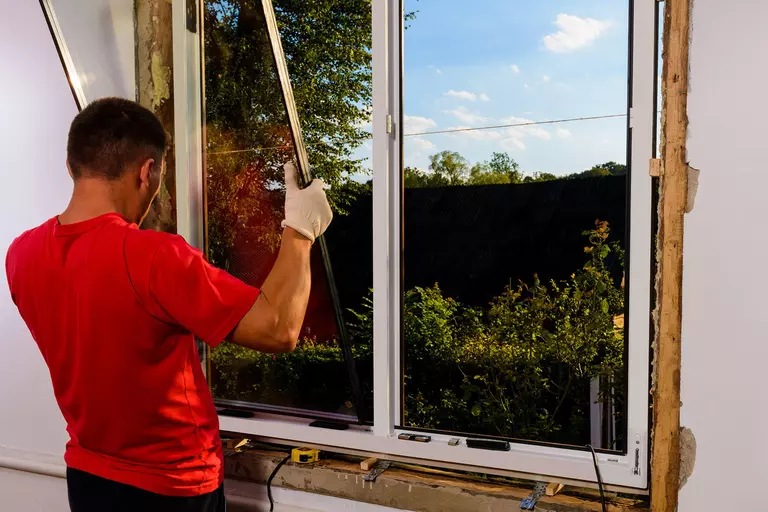 Expert installing new windows on a house.