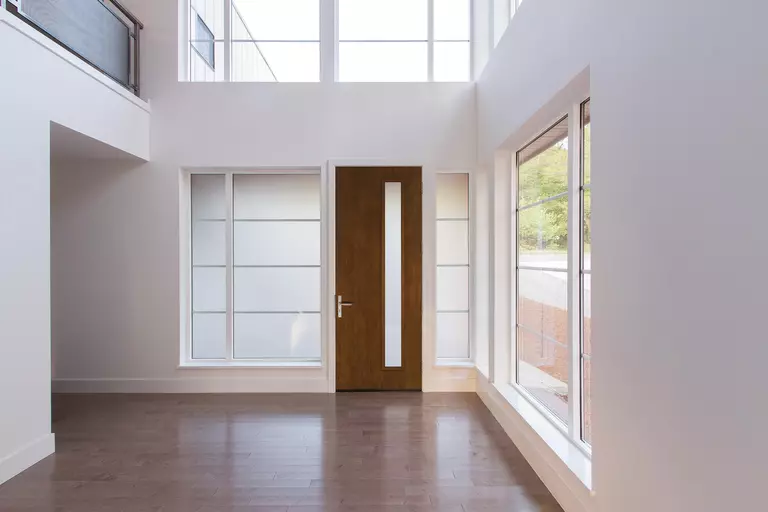 A modern entry door with a vertical panel.