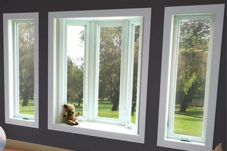 A wall with darker paint and a bay window with a pair of casement windows and white frames.