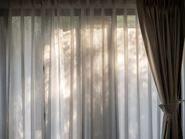 Living room of a home with curtains in front of big windows