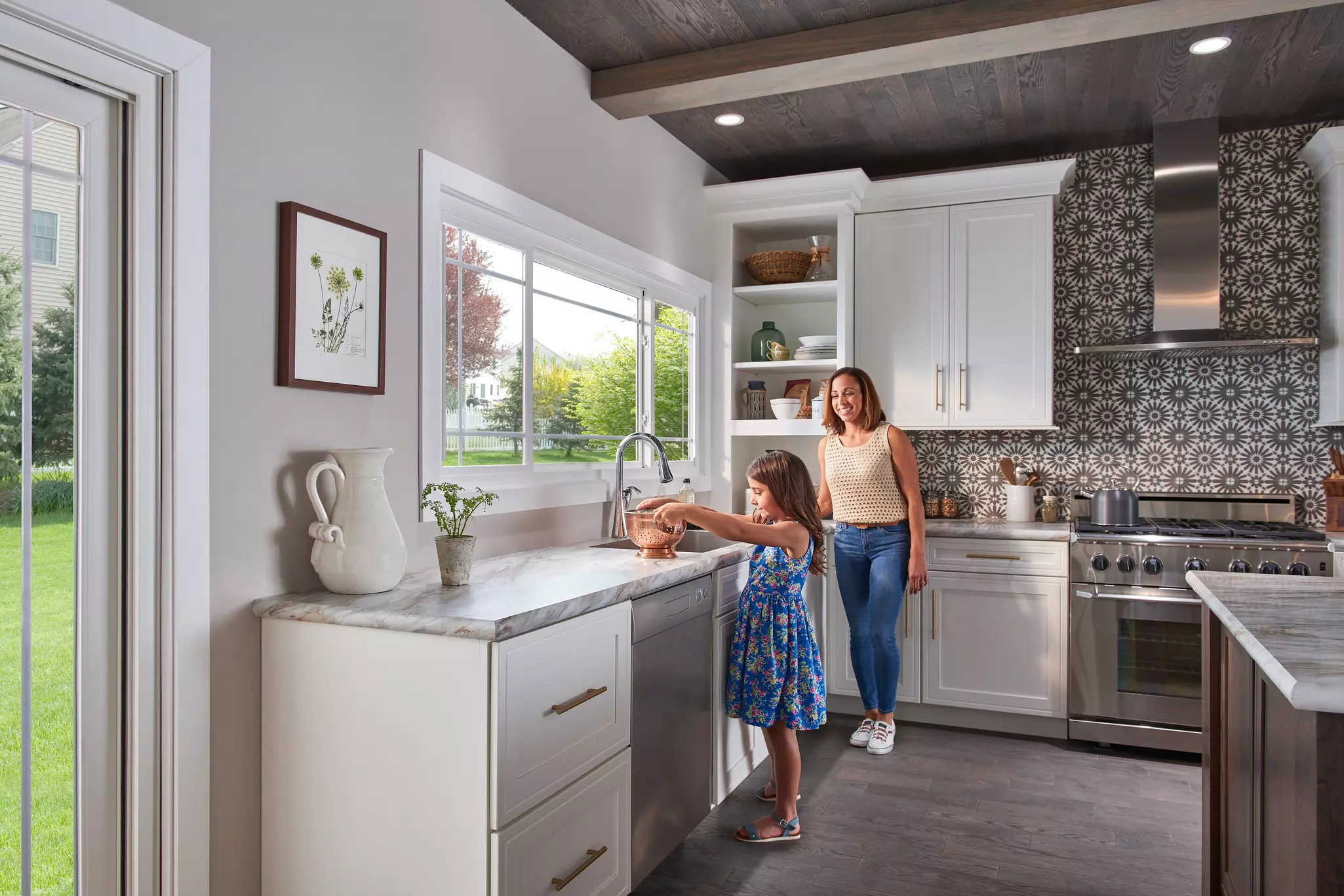 Woman and daughter in a kitchen featuring a sliding window.