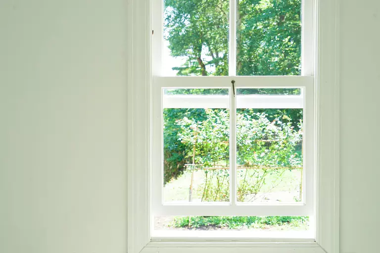 A double-hung window that is slightly open.