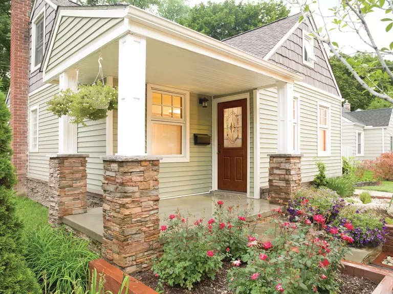 Home featuring a woodgrain door with a large decorative glass window.