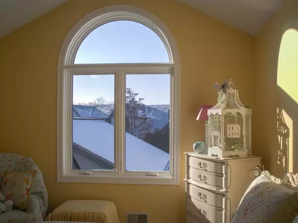 Restorations series white casement and specialty shape windows in a bedroom