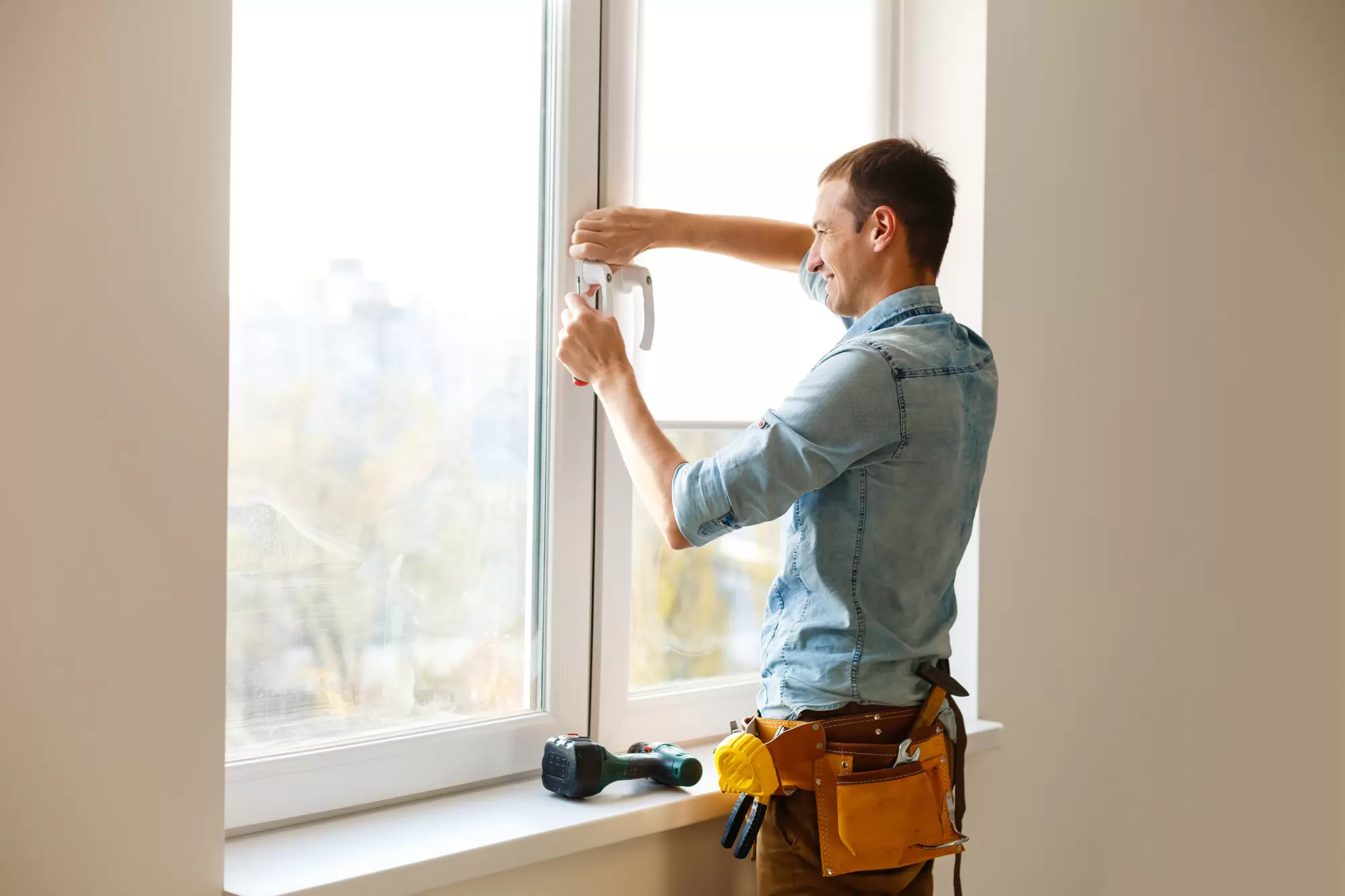 Installer working on a large, white-framed window.
