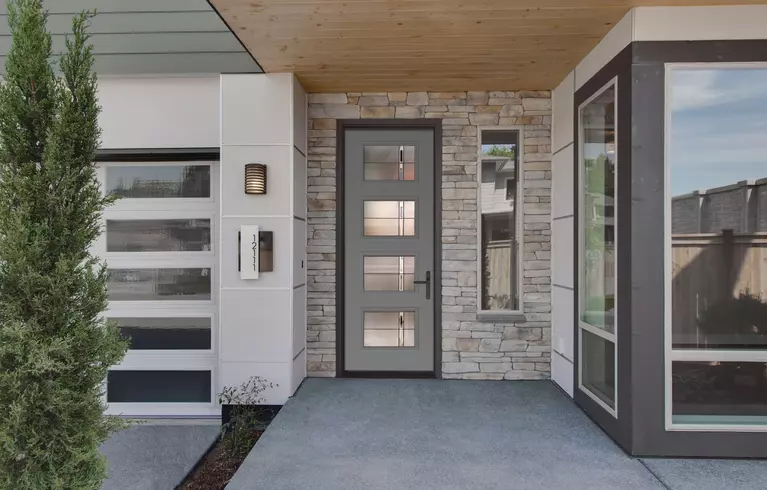 A modern entry door on a mid-century modern home with stacked stone and geometric detailing.