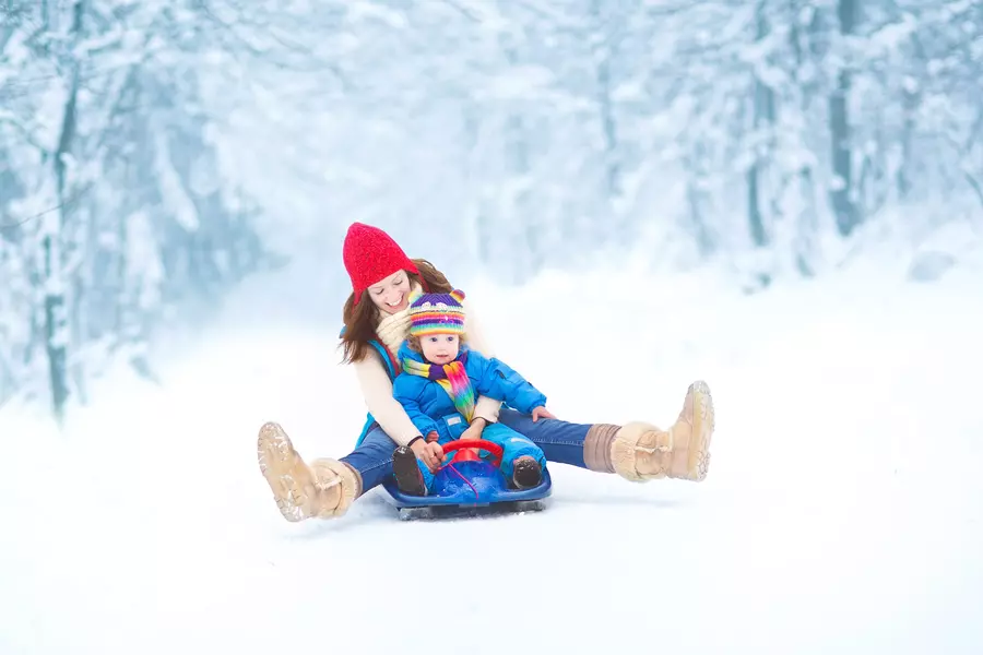 A mother and her daughter enjoying an outdoor winter activity
