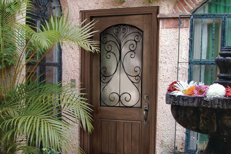 A woodgrain front door with Camelia decorative glass.