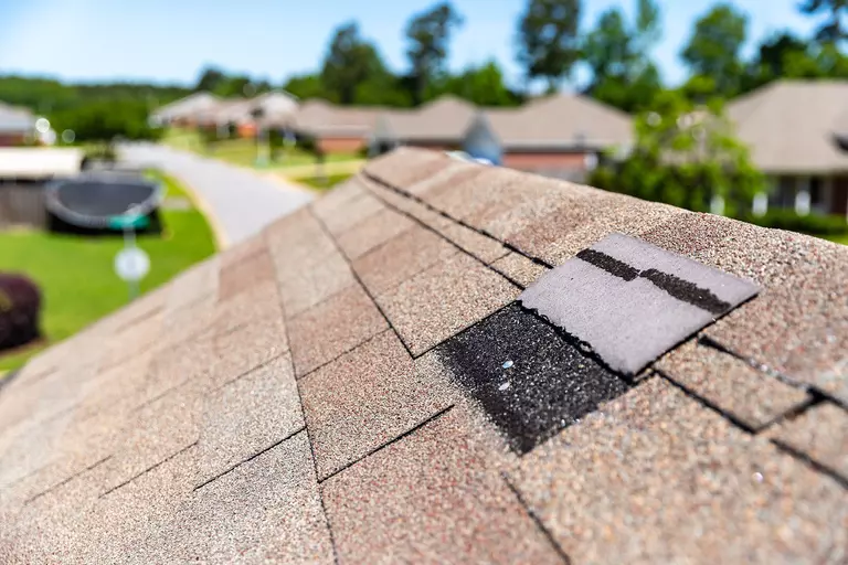 A shingle on the roof of a home that has come off.