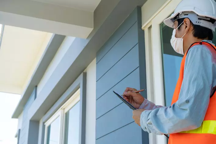 Contractor taking notes on home exterior