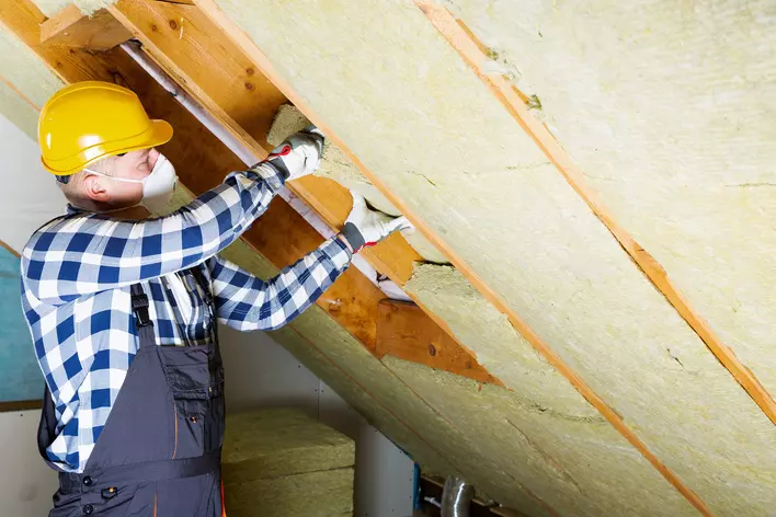 A contractor installing insulation for the roof of a home to help prevent heat from
escaping in the colder months.