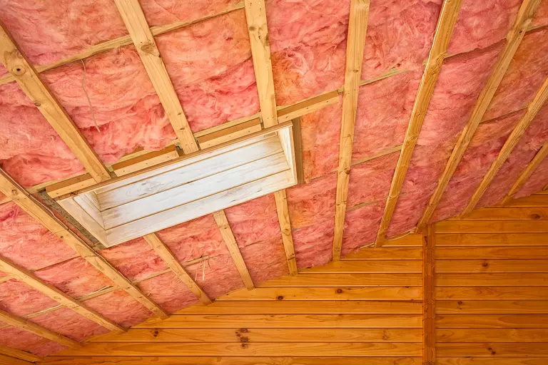 Interior of a roof with batt insulation.