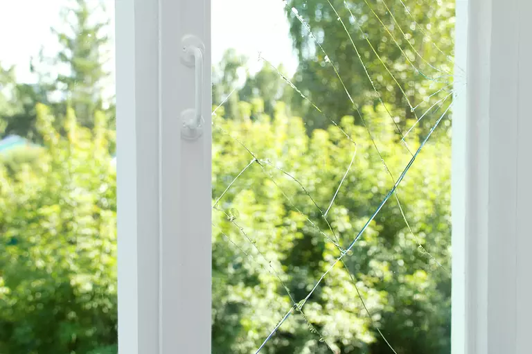 Closeup of a window with a cracked glass pane.