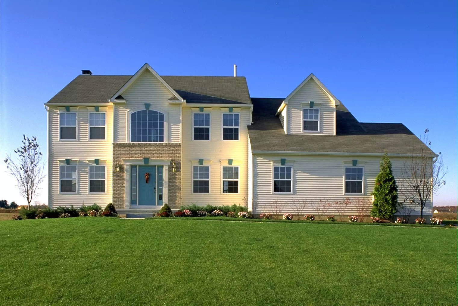 White colonial home with south-facing windows on a sunny day.