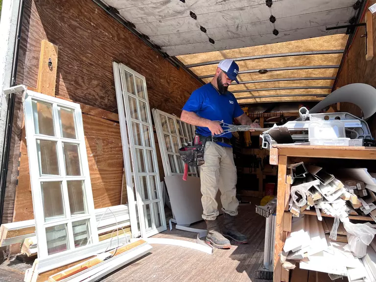 Window World installer in the back of a truck preparing windows.
