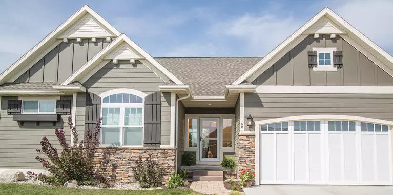 A large home pictured on a sunny day. Its modern storm door gives it immense curb appeal.