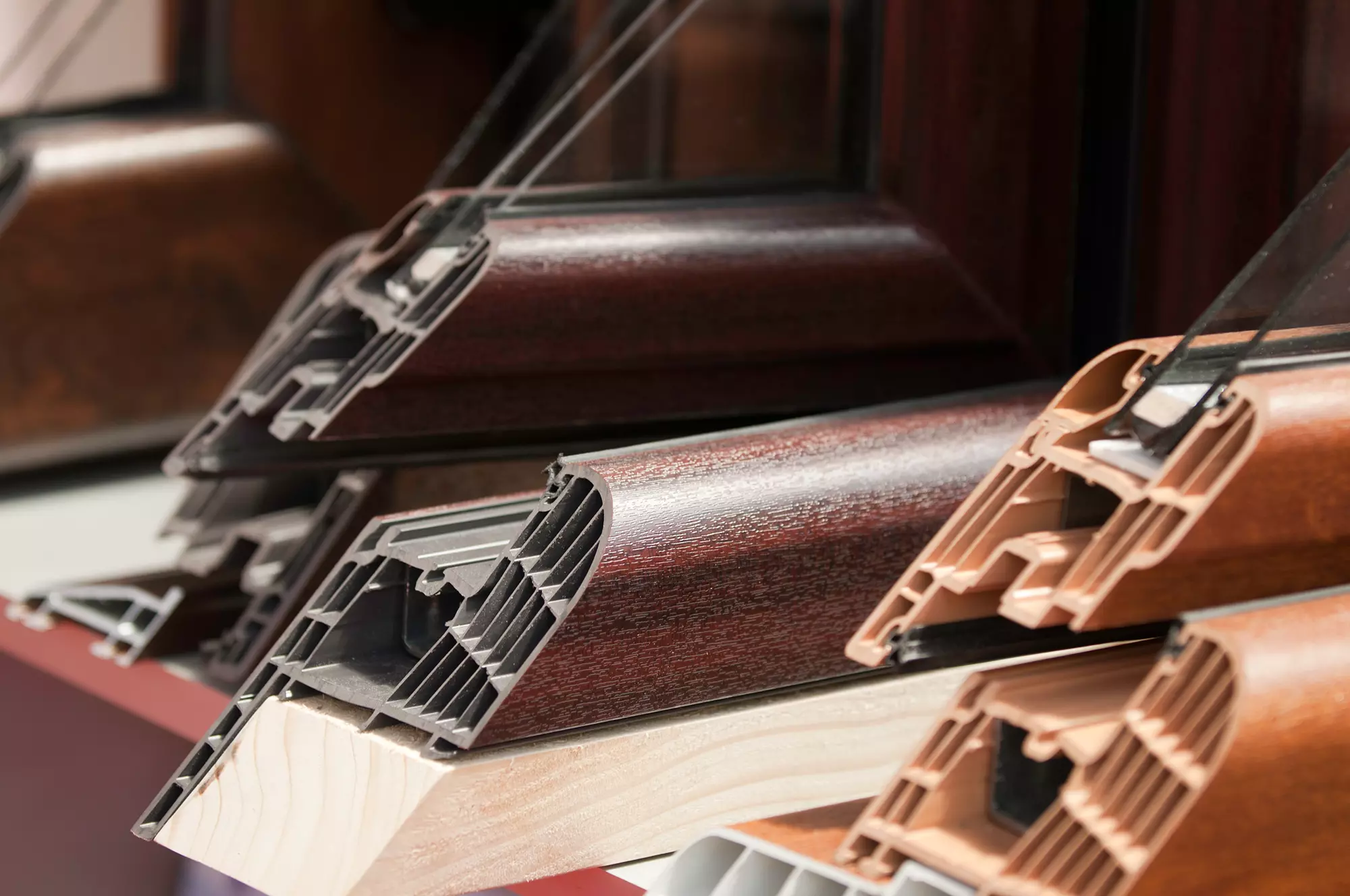 Close-up of woodgrain window frame samples showing cross-sections and layered materials.