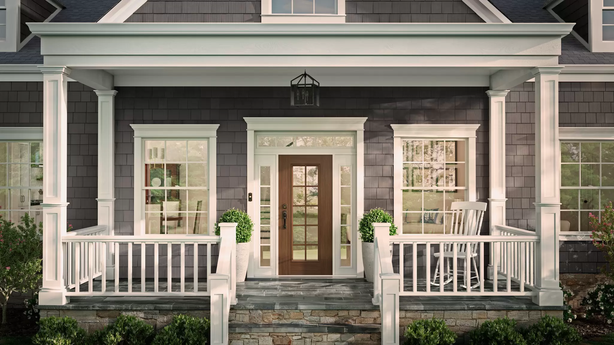 Front of a house with double-hung windows with white trim and a brown wooden door.