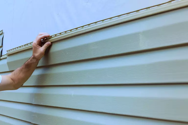 Close-up of a worker installing siding.