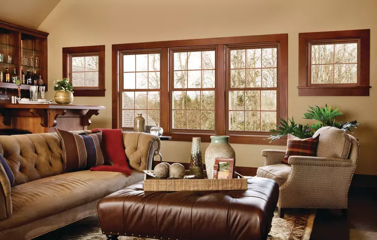 A living room with three rectangular windows and a pair of square windows with wood-look frames.