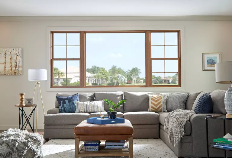Large energy-efficient windows behind a gray couch.