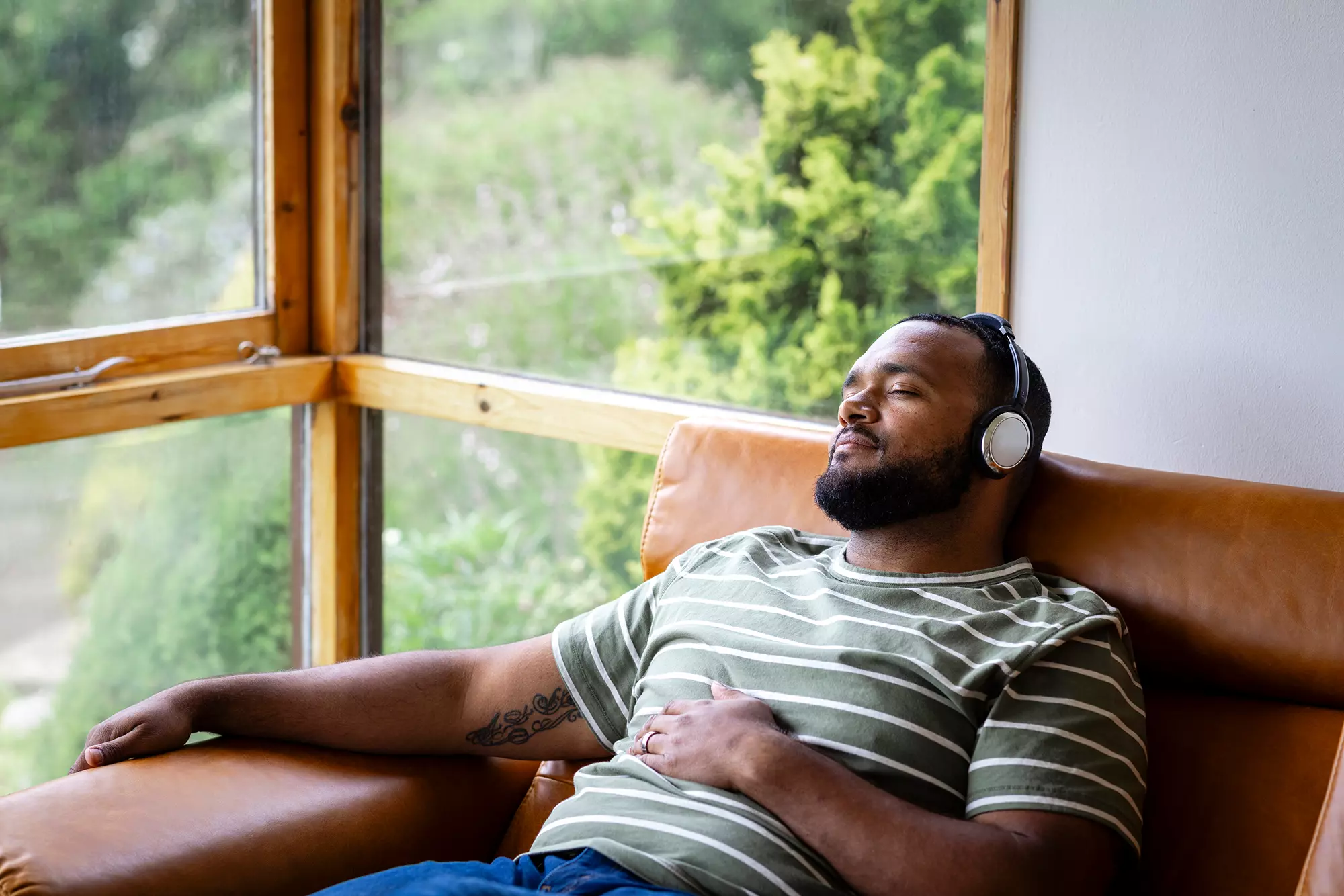Man wearing headphones inside a sunroom.