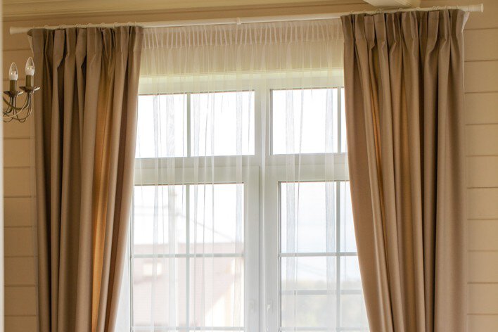 Tan curtains hung above a white window