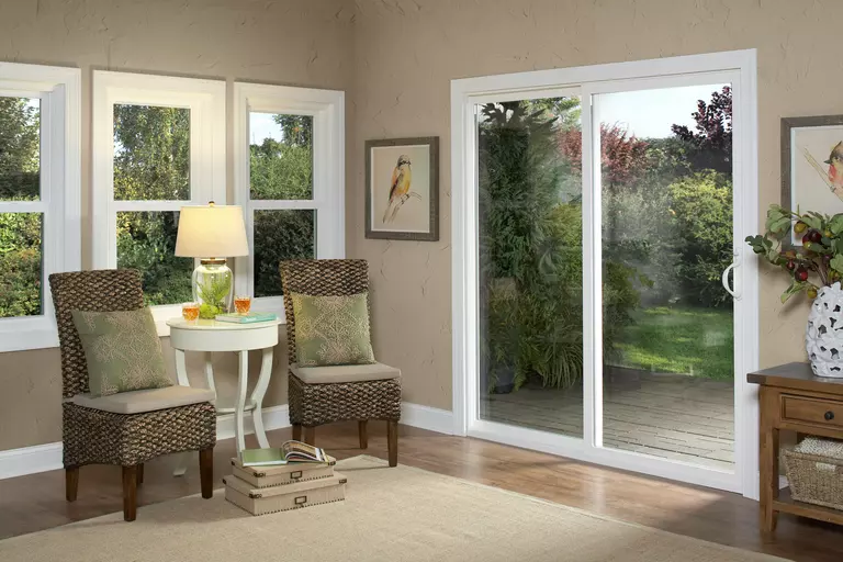 A brightly lit seating room of a home with a sliding patio door to the outside deck.