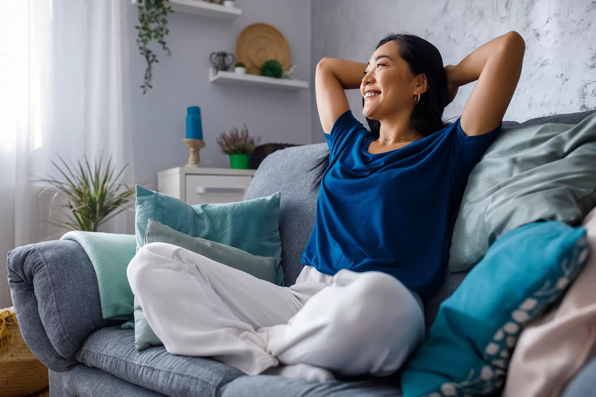 Woman sitting on a couch and smiling.