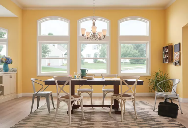 Double-hung windows in a dining room with yellow walls.