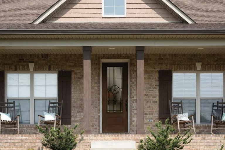 An entry door with Elegant Star decorative glass on a brick-front house.